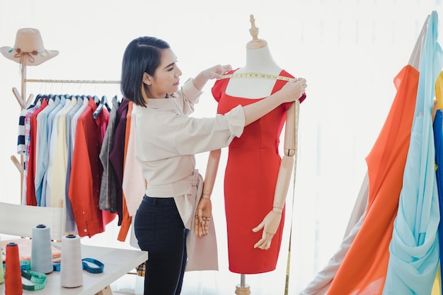 Un designer professionnel mesure la taille des vêtements coupés avec un ruban à livrer au client. Les créateurs de mode vérifient de nouveaux vêtements.