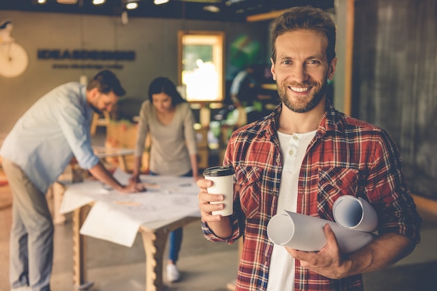 designer tient papier et tasse de café