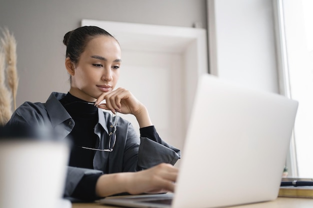 Une designer travaille en ligne utilise un ordinateur portable écrit un message de réponse au client par courrier