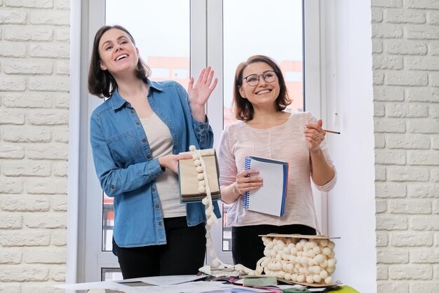 Designers de femmes travaillant dans le design d'intérieur choisissant des échantillons de tissus et d'accessoires pour rideaux