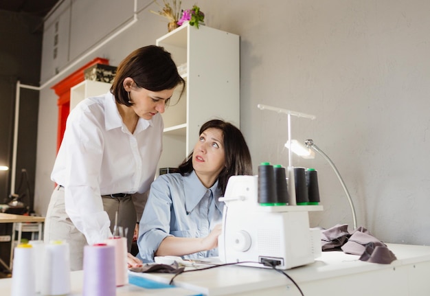 Un designertailor forme une personne à la couture Le concept de création de vêtements