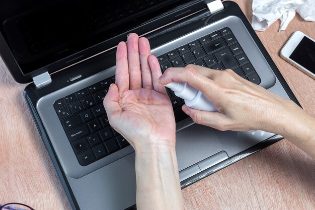 Désinfection des mains avec hydrogel sur table de travail