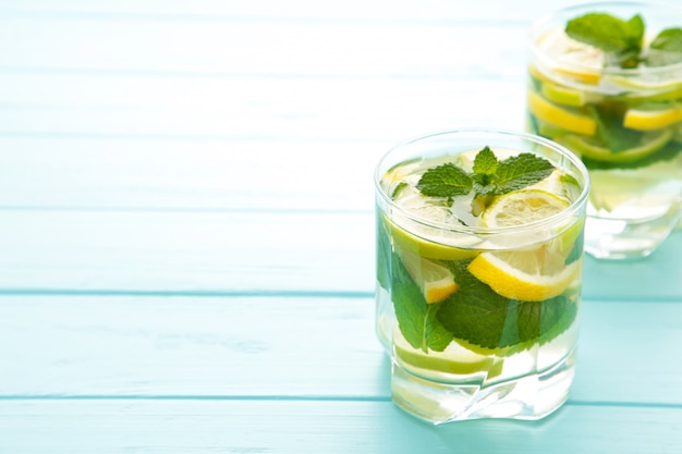 Désintoxication à l'eau au citron, citron vert et menthe sur fond bleu. Boisson détox avec copie espace