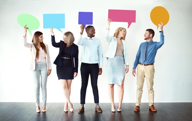 Désolé qu'avez-vous dit Photo d'un groupe de collègues de travail debout les uns à côté des autres tout en tenant des bulles sur un fond blanc