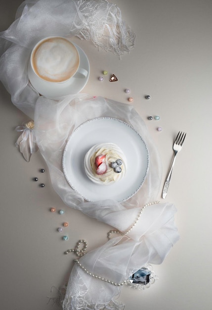 Dessert Anna Pavlova avec fraise et myrtille sur une plaque blanche