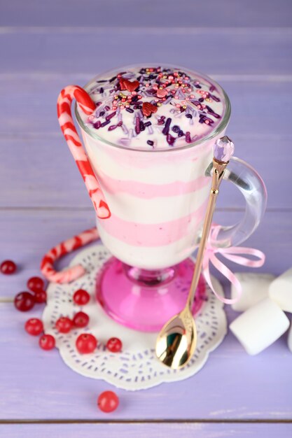 Dessert au lait de canneberge en verre, sur une surface en bois de couleur