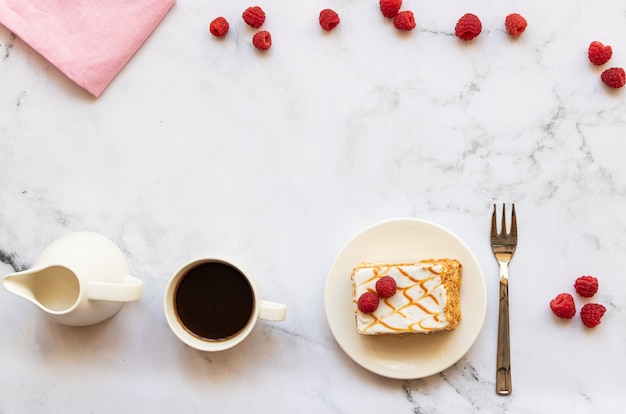 Dessert aux framboises et tasse de café noir sur marbre