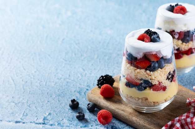 Dessert de bagatelle avec des baies et de la crème sur le fond bleu