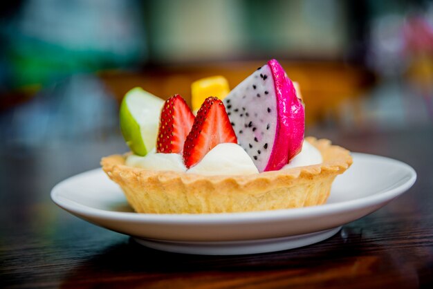 Dessert de biscuits et de crème pâtissière, décoré de fruits.