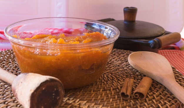 Dessert brésilien sucré de citrouille à la noix de coco et à la cannelle dans un bol et une table en bois