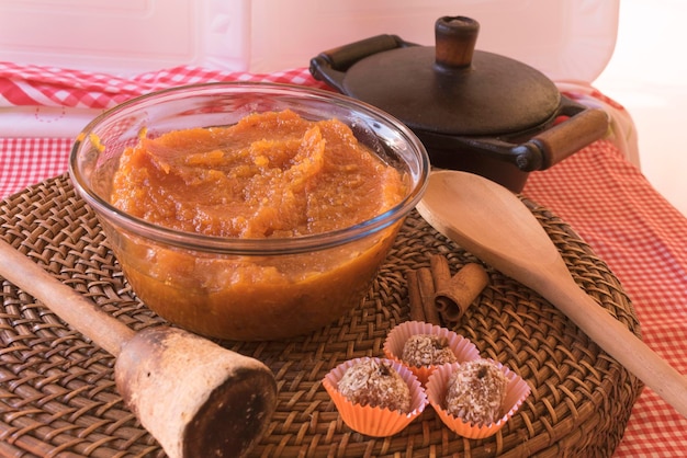 Dessert brésilien sucré de citrouille à la noix de coco et à la cannelle dans un bol et une table en bois