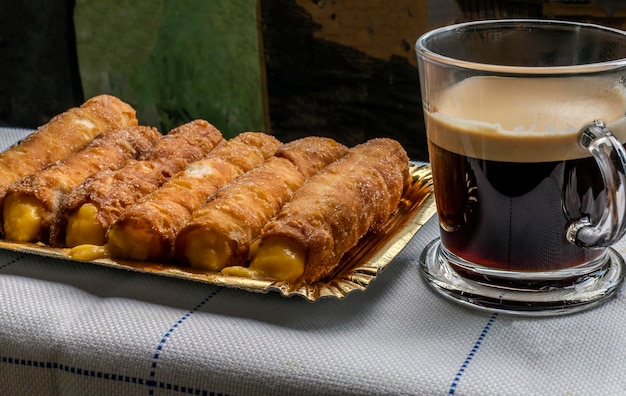 Dessert Canes remplies de crème de pâtisserie accompagnées d'un café
