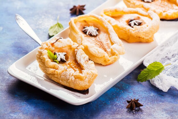 Dessert chaud délicieux: poires cuites au four dans une pâte sur un fond en bois rustique