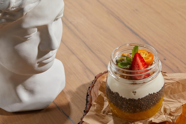 Dessert avec confiture de soufflé blanc et graines sur une table en bois