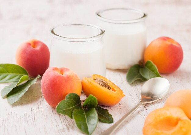 Dessert à la crème fraîche aux abricots biologiques crus sur planche de bois.