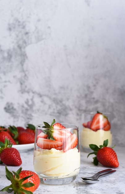 Dessert avec crème et fraises sur une surface en béton