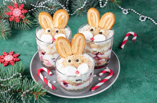 Dessert du Nouvel An dans des verres en forme de lapins mignons avec des biscuits aux cerises et de la crème de caillé Symbole de la nouvelle année 2023