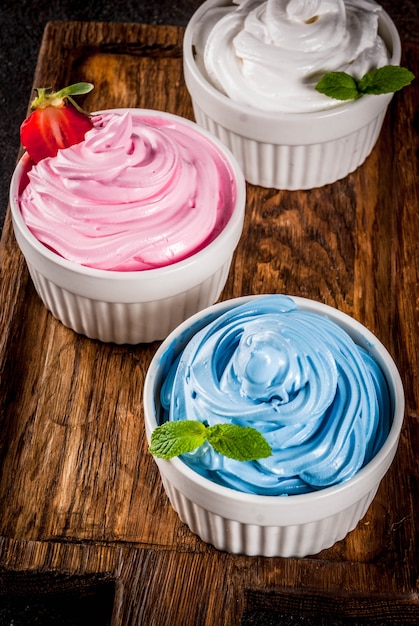 Dessert d'été pour régime alimentaire sain, yogourt glacé à la vanille et aux baies ou crème glacée molle dans des bols blancs