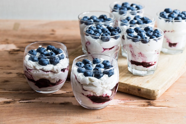 Dessert fait maison avec du yaourt à la grecque et de la crème, de la confiture de myrtilles et des baies de myrtilles fraîches