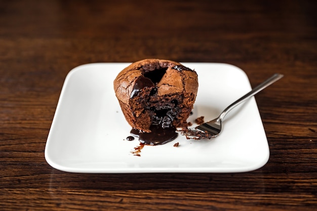 Dessert fondant au chocolat sur une assiette blanche et une fourchette