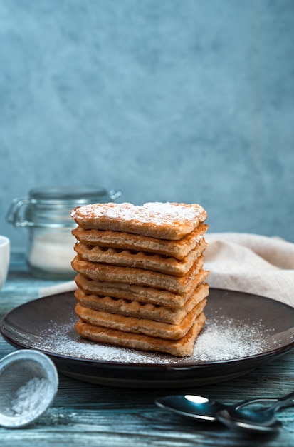 Dessert français, gaufres en forme de coeur au cacao sur un fond gris en bois.