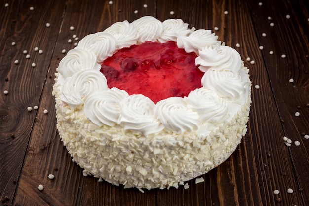 Dessert gâteau aux fraises avec des bonbons sur fond de bois