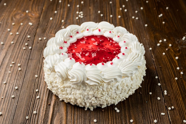 Dessert gâteau aux fraises avec des bonbons sur fond de bois