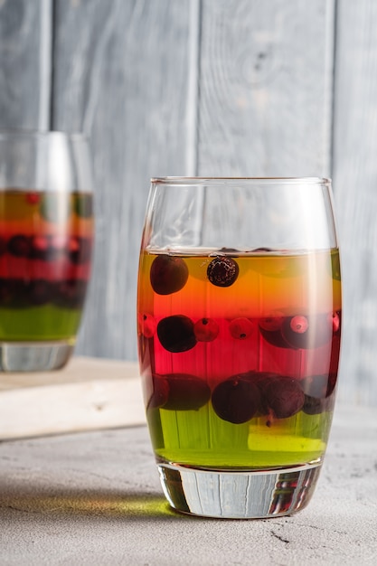 Dessert de gelée aux fruits rouges dans des verres sur une vieille planche à découper en bois