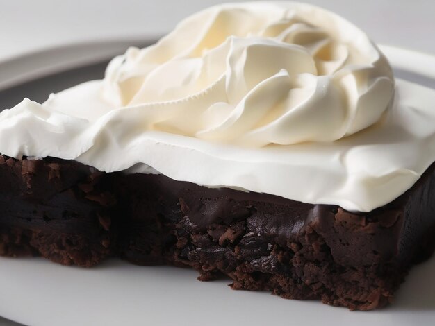 Un dessert gourmet indulgent, un brownie au chocolat fait maison avec de la crème fouettée.