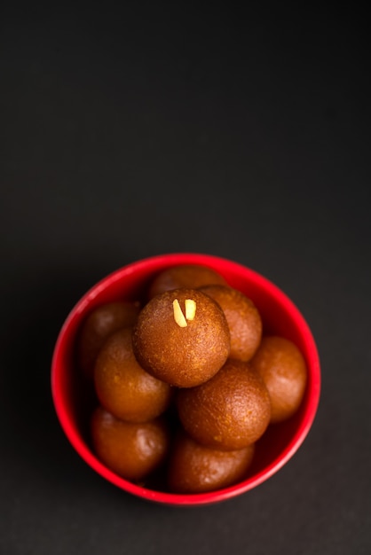 Dessert indien ou plat sucré Gulab jamun dans un bol à l'obscurité.