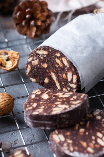 Dessert italien traditionnel - salami au chocolat de noël avec des biscuits cassés et des noix sur une table