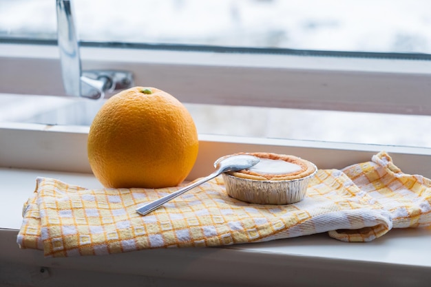 Dessert local sur napery avec orange à côté de la fenêtre en hiver