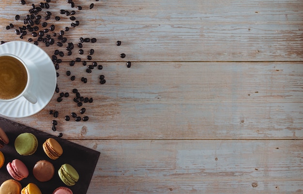 Dessert de macarons français avec une tasse de café et des grains de café Copy space