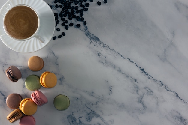 Dessert de macarons français avec une tasse de café et des grains de café Copy space