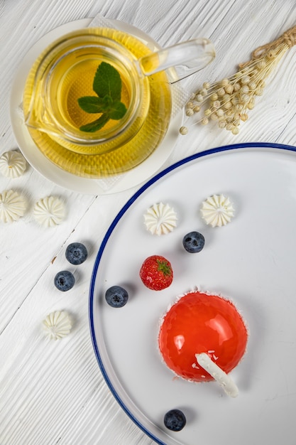 Dessert mousse sur une assiette bleue et une table en bois blanc