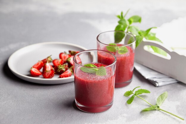 Dessert mousse aux fraises maison et assiette avec baies fraîches sur fond de béton clair