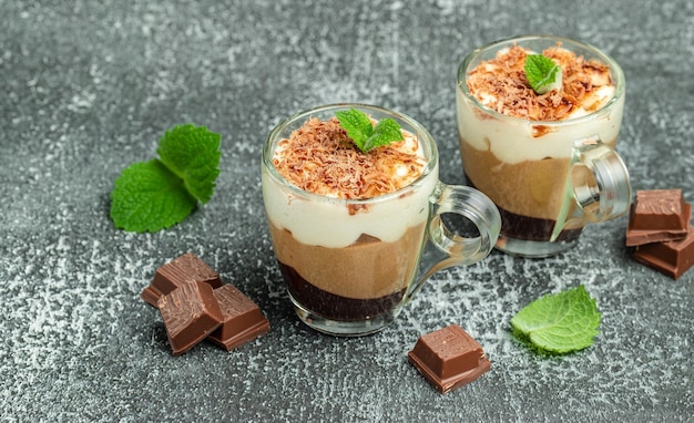 Dessert mousse trois chocolats à la menthe sur fond sombre Délicieux dessert en couches Format bannière longue