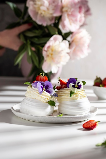 Dessert de pavlova sucré décoré de fraises fraîches et de fleurs