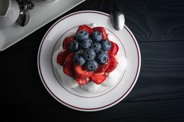 Dessert Pavlova sur une table en bois sombre