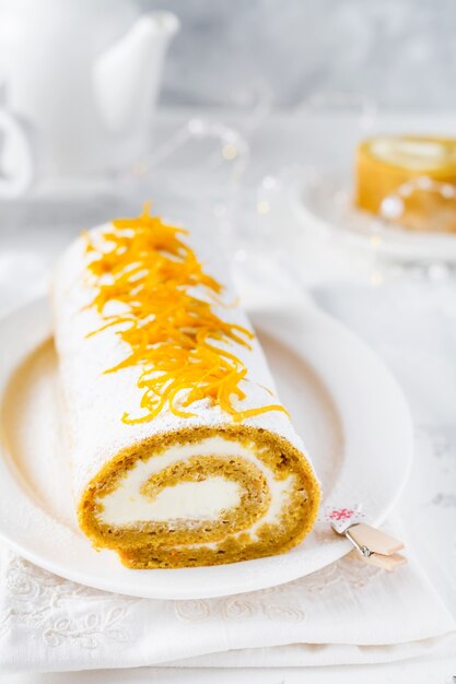 Dessert rouleau de potiron à la crème au beurre et à l'orange sur fond gris clair