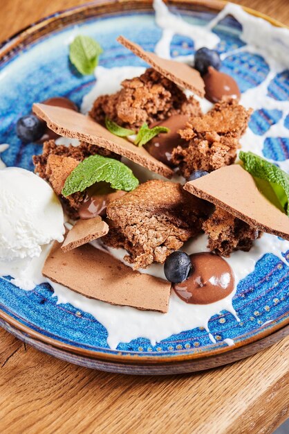 dessert salé au chocolat avec crème glacée sur une assiette bleu vintage sur une table dans un restaurant pâtisserie