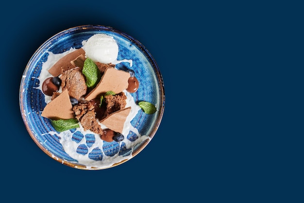 dessert salé au chocolat avec crème glacée sur une assiette bleue vintage sur fond bleu propre