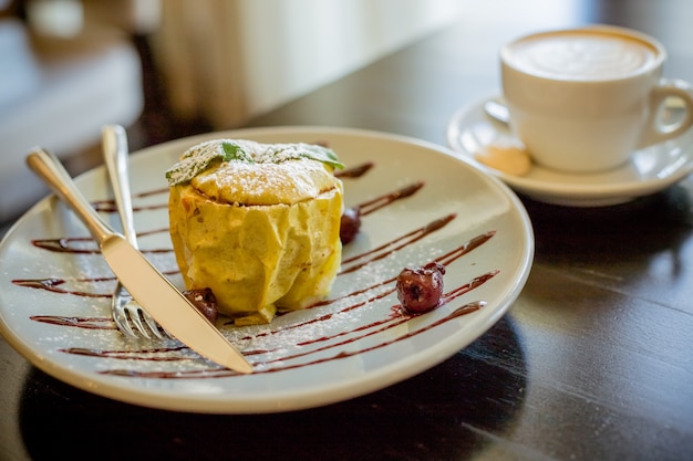 Dessert savoureux, pomme farcie à la cannelle, noix et miel sur une plaque blanche