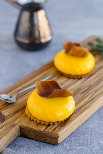 Dessert sucré Gâteaux aux pêches jaunes avec une tranche de chocolat sur le dessus sur une planche à découper en bois et cezve