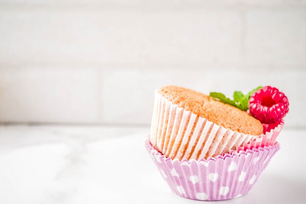 Dessert sucré, muffin au four maison avec confiture de framboises, servi avec thé, framboises fraîches et menthe