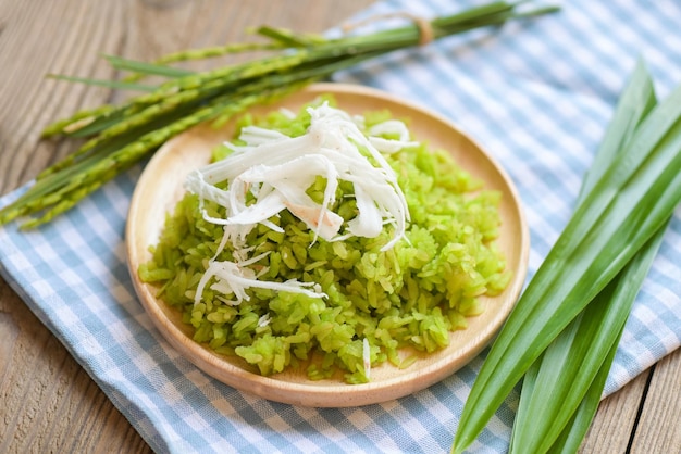 Dessert thaïlandais riz non mûr pilé nourriture flocons de riz céréales avec noix de coco et sucre Riz vert sucré avec des épis de riz feuille de pandan Dessert alimentaire ou collations Nom Khao Mao en Thaïlande