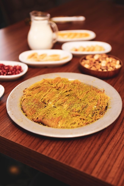 Dessert turc kunefe kunafa kadayif avec de la poudre de pistache et du fromage chaud mangé un bonbon