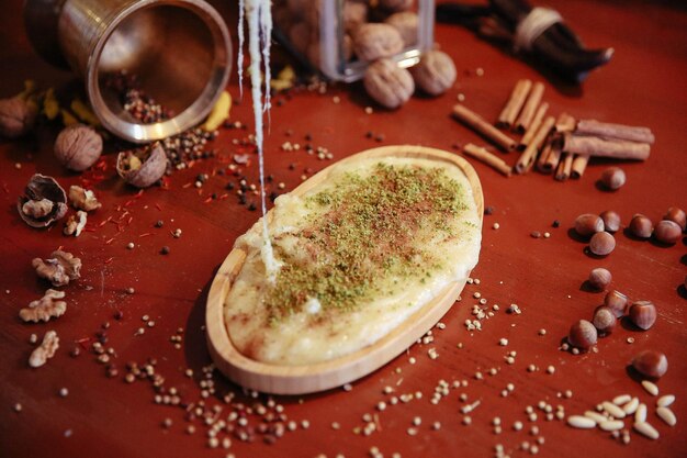 Dessert turc kunefe kunafa kadayif avec de la poudre de pistache et du fromage chaud mangé un bonbon