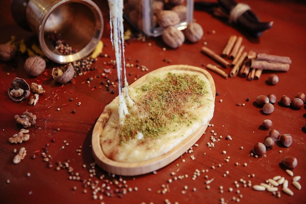 Dessert turc kunefe kunafa kadayif avec de la poudre de pistache et du fromage chaud mangé un bonbon