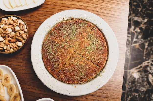 Dessert turc kunefe kunafa kadayif avec de la poudre de pistache et du fromage chaud mangé un bonbon